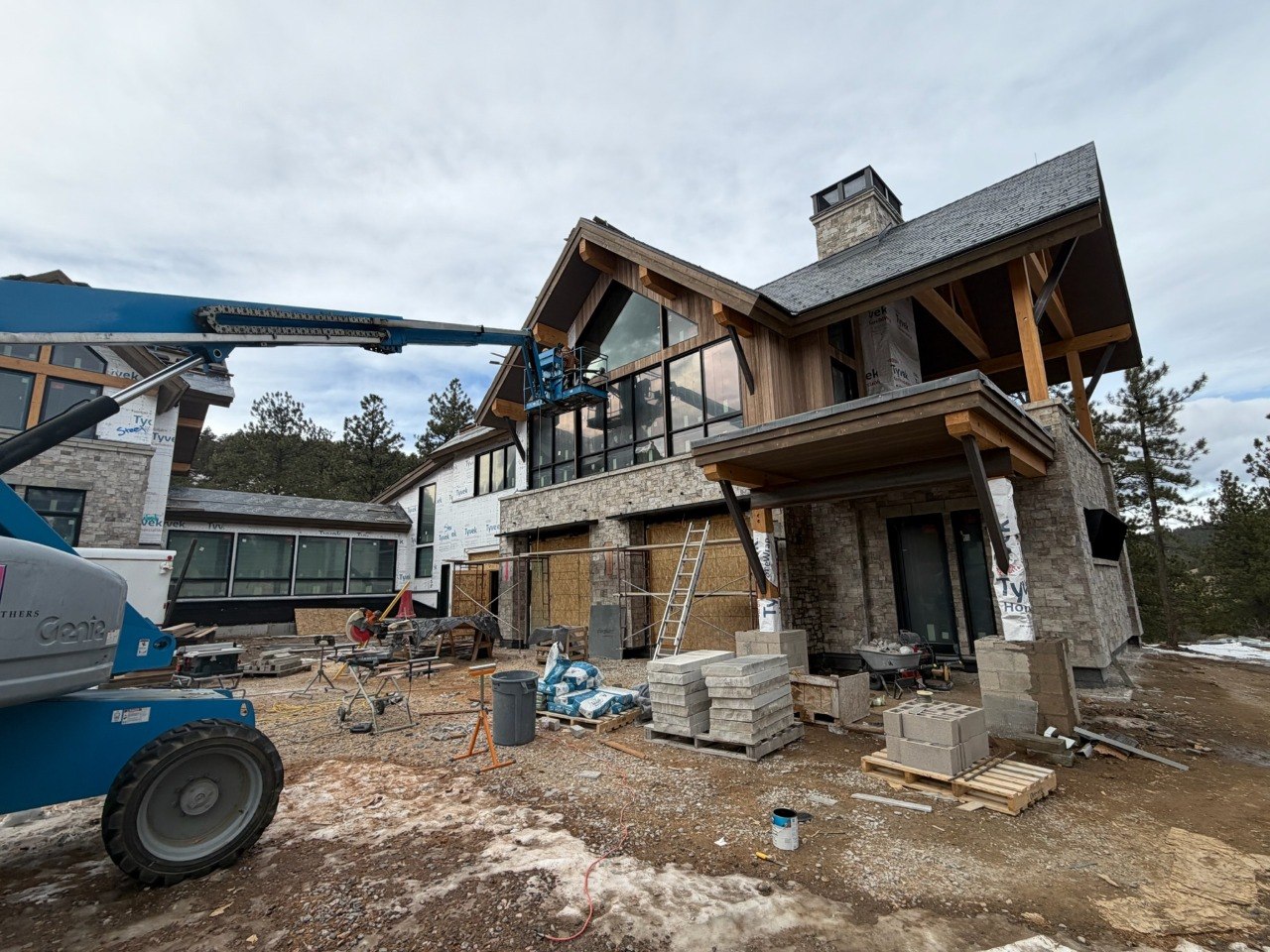 Luxury home window installation using a lift on an active job site