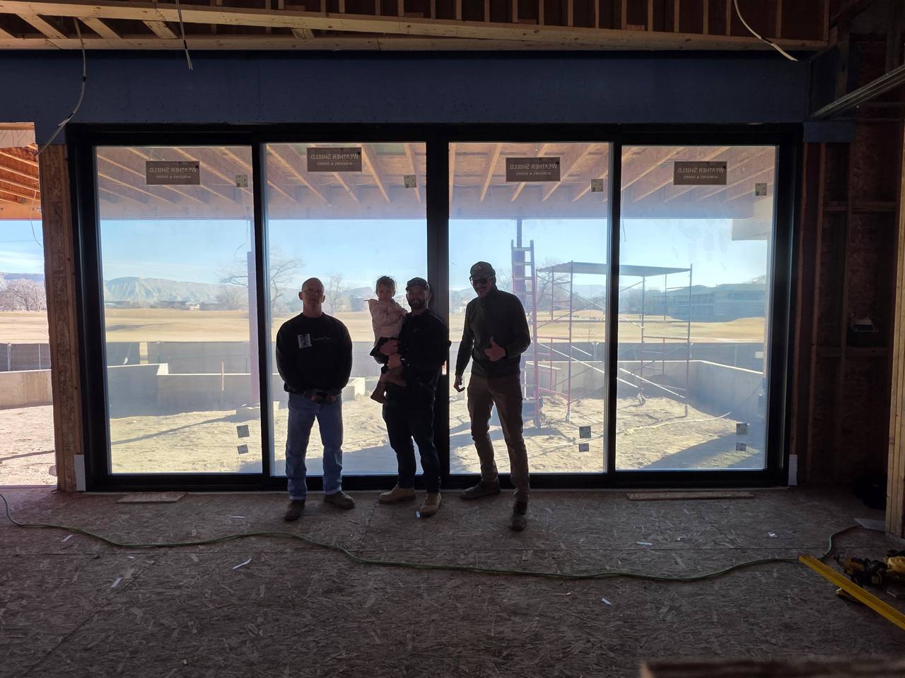 Installation team standing inside a large scenic door opening on a job site